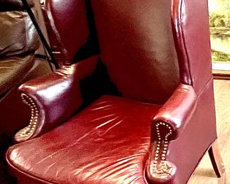Two maroon wing back chairs. Some damage to top of headrests.