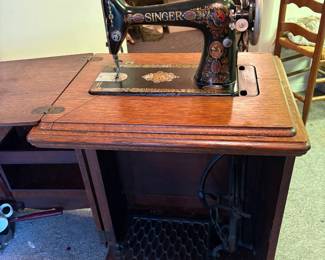 Antique Singer Sewing Machine with Cast Iron Construction and ornate cabinet