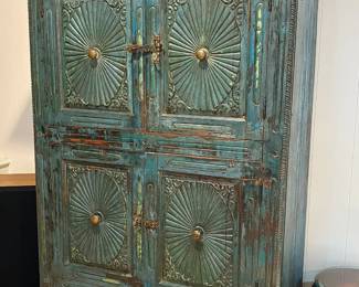 Rustic carved wood and distress-painted almirah cabinet with sunburst motifs.