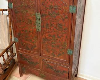 Antique Chinese red lacquered cabinet decorated with pagodas and traditional motifs