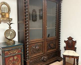 Late 19th century French Renaissance Revival oak bookcase and with barley twist pilasters and English oak hall chair.