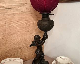 Antique Victorian bronze cherub oil lamp with original red satin glass globe, electrified.