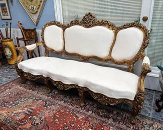 French Rococo style giltwood sofa with white upholstery, 20th century.