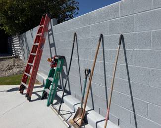 Assorted ladders, shovels, and yard tools