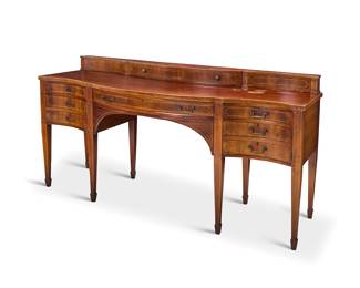 319 A George III style mahogany sideboard 20th century With single upper drawer above a serpentine front with seven drawers, raised on attenuated legs ending in spade feet Metal tag to drawer interior: STIEHL FURNITURE / NEW YORK Height 40 3/4 in., width 78 in., depth 29 in. Estimate: $600 - $800