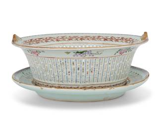 326 A Chinese Export reticulated porcelain armorial bowl and stand 19th century Painted with a heraldic shield with a white stag on a red background paired with blue and gold diagonal stripes, surrounded by ornate mantling and a ribbon scroll Height overall 4 1/2 in., width across handles 10 in., depth of basket 9 in.; stand 8 3/4 x 10 1/4 in. Estimate: $700 - $900