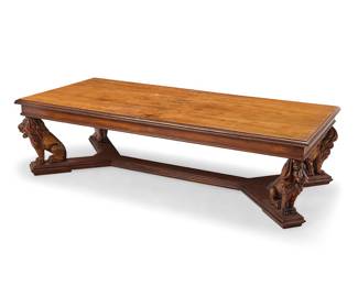 391 A Renaissance Revival style carved hardwood coffee table Late 20th/early 21st century The tabletop with book-matched veneer and ogee beveled edge, raised on four seated lion supports on a platform cross-stretcher Height 20 1/8 in., width 75 in., depth 37 in. Estimate: $600 - $800