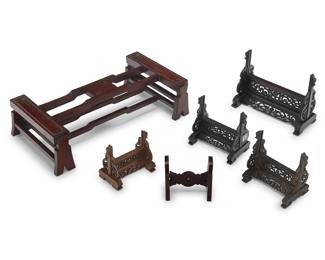 70 A group of six Chinese hardwood stands Late Qing dynasty (1644-1912) and later Comprising one larger of unusual form, four pierced wood plaque stands, and another 6 pieces Height of largest 4 1/2 in., width 17 in., depth 8 3/4 in.; widths of plaque openings 7 1/2, 4 5/8, 4 3/4, and 3 5/8 (x2) in. Estimate: $700 - $900