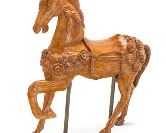 396 A carved wood carousel horse Second half 20th century With roses in high relief, incised with foliate motifs beneath saddlery, supported on metal poles Height 56 in., width 56 in., depth 14 in. approximately Estimate: $1,000 - $2,000