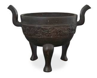 45 An Asian bronze tripod censer 20th century or earlier With band of archaic beasts and masks in relief Height 6 7/8 in., width 9 1/4 in., depth 6 1/2 in. Estimate: $700 - $1,000