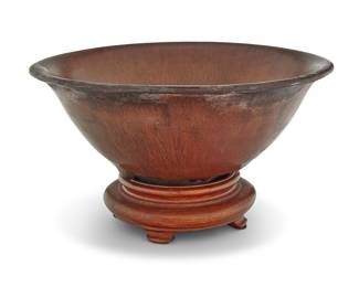 109 A Chinese Jianyao glazed ceramic 'Hare's Fur' bowl with mark Song dynasty (960-1279 CE) or later Covered inside and out with a viscous black and russet glaze of densely patterned striated lines, the exposed stoneware body fired reddish tan Incised to the base with an unidentified makers' mark Height 2 5/8 in., diameter 6 1/2 in. Estimate: $1,200 - $1,800