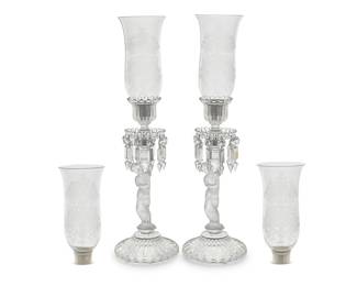 147 A pair of Baccarat glass 'Enfant Lusters' candlesticks and four shades Mid-20th century Comprising a pair of bases with cut glass drop elements and a set of four shades Each base and shade etched with factory mark 6 pieces Height of each base 15 in., diameter 6 1/4 in.; height of shades 9 1/8 in., diameter 4 7/8 in. Estimate: $800 - $1,200