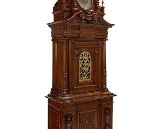269 A Polyphon Musikwerke music box clock Circa 1890; Leipzig, Germany With dual combs playing 24 5/8 in. discs (11 included with the lot), housed in a walnut case with architectural stylized details and a central beast mask; the clock with silver and gilt dial bearing Arabic numerals, the lower left side cabinet door opening to the disc storage Movement marked: FONTENOY / MADE IN FRANCE / 16/163 / F 40 Height overall 9 ft. 2 1/2 in., width 45 in., depth 24 1/2 in. Estimate: $5,000 - $8,000