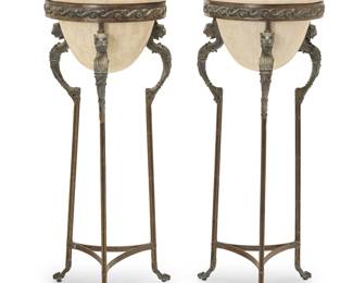 359 A pair of Kreiss Furniture athéniennes Late 20th/early 21st century The bronze tripod stand with lion's head accents, supporting a marble veneered ceramic planter One with metal tag: KREISS COLLECTION 2 pieces Height of each 48 1/2 in., width 20 1/4 in., depth 21 in. Estimate: $700 - $900