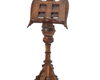 328 A Gothic Revival carved oak lectern Late 19th/early 20th century The eagle-form stand with an easel-backed hinged element to adjust reading angle, above a turned wood and X-form pedestal base, mounted with later brass single light, electrified Height 71 1/2 in., width 27 1/2 in., depth 25 in., approximately Estimate: $1,500 - $2,000