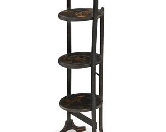 332 A japanned three tiered cake stand Early 20th century With upper handle and raised on splayed feet, each tier decorated with gilt-painted figural tableaus in bas relief Height 36 1/2 in., width 10 1/2 in., depth 11 in. Estimate: $600 - $800