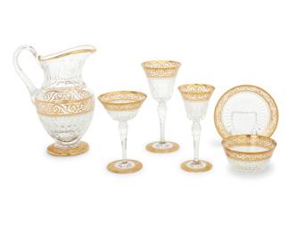 3 A St. Louis gilt cut glass ‘Stella Gold’ stemware service 20th century Comprising: 10 red wine glasses (7 7/8 in.) 8 white wine glasses (6 3/4 in.) 9 champagne coupes (6 1/8 in.) 10 finger bowls (4 1/2 in.) 10 dishes (5 3/4 in.) 1 pitcher (height 9 1/2 in., width 7 in., depth 5 1/8 in.) Each with acid etched factory mark 48 pieces $1,200-1,800