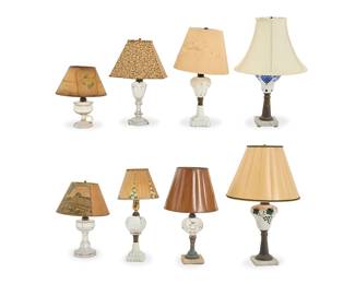 285 A group of American pressed glass fluid lamps Mid-19th century with later components Each single-light lamp with various styles of paper or fabric shade, three on a stone base, electrified One marked with date in the molding: OIL GUARD LAMP / 1870 7 pieces Total heights 12 1/4-23 1/2 in. Estimate: $700 - $1,000