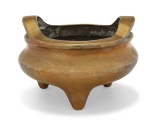 46 A Chinese brass tripod censer Qing dynasty (1644-1912) or later Molded with dragon motif to underside, with opposed handles Impressed with reign mark for Xuande period (1426-1435) Height 5 1/4 in., diameter 7 3/4 in. Estimate: $500 - $700