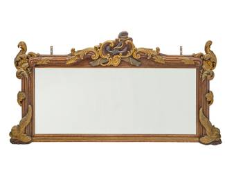 85 A late Victorian parcel gilt carved wood overmantel mirror Late 19th/early 20th century The rectangular frame ornately carved with foliate motifs, flanked by dolphins and crested by a nautical trophy Height 48 in., width 94 in., depth 4 1/2 in. approximately Estimate: $600 - $800