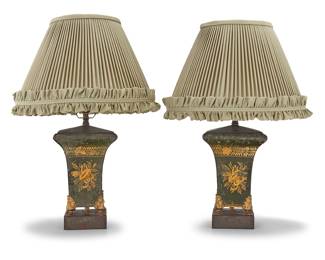 331 A pair of French painted and gilt tole table lamps 19th century Each with three sides decorated in gilt with a musical instrument trophy, on paw feet, fitted with a later single-light fixture and a pleated fabric shade, electrified 2 pieces Height of each without harp 14 1/2 in., width 6 1/2 in., depth 6 1/2 in.; heights overall 21 1/2 in.; height of shades 9 1/2 in., diameter 15 1/2 in. Estimate: $600 - $800