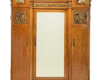 261 An Italian Art Deco gilt bronze mounted wardrobe Second quarter 20th century With central mirror door, opening to reveal an upper tension rod, three shelves, and a drawer, the left with three shelves and the right with two tension rods, each side door with interior mirror, flanked by upper single light lamps with beaded fringe shades, above gilt-bronze panels depicting frolicking putti above side cabinets, each with marquetry floral elements, electrified Height 8 ft., width 7 ft., depth without lamps 25 in.; depth with lamps 37 in. Estimate: $1,000 - $2,000