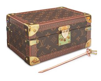341 A Louis Vuitton Monogram Coffret Trésor 24 jewelry box Circa 2006, France The small case in LV monogram canvas with printed monogram cowhide trim, golden brass toned branded hardware including front S-lock, and all corners, the interior lined with pale red microfiber, with branded keys on leather key fob With stitched embossed leather label to inside lid: Louis Vuitton / Paris / made in France; embossed date stamp to interior front right: AS0036 Height 5 1/8 in., width 9 3/4 in., depth 6 5/8 in. Estimate: $1,500 - $2,000