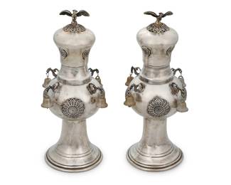 43 A pair of Continental sterling silver Rimonim Late 19th/early 20th century Each Torah scroll finial decorated with openwork scroll medallions, with dragon-form accents and bird finial, mounted with bells, later in-filled with plaster Each appears unmarked 2 pieces Height of each 9 1/4, diameter 4 7/8 in. approximately Estimate: $800 - $1,200