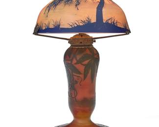 248 A Michel de Nancy cameo glass landscape boudoir lamp Early 20th century The single-light lamp standard decorated with ivy, the shade depicting a lakeside scene, electrified Marked in the cameo of base: [cross of Lorraine] Michel / de Nancy Height 14 in., diameter 8 1/4 in. Estimate: $600 - $800