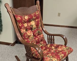 Pressed wood antique rocking chair with rose themed chair pads.  Very nice!  Sewing room, basement left.