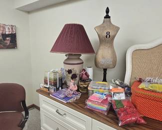 The cream colored dresser is a cabinet of 12 drawers, made by California Closets.