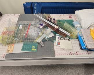Cutting mats and quilting guides/rulers.  They are displayed on an antique four-poster twin bed.