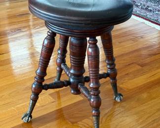 Antique swivel piano stool w/turned wooden legs and iron claw-and-ball feet holding glass balls