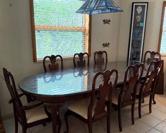 Mahogany dining table w/8 chairs, glass top, and full table pads. Chairs need reinforcement and re-upholstering. Priced to sell!