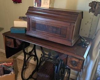very old sewing machine with covered cabinet 