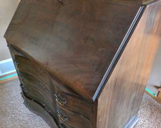 Governor Winthrop-style drop-front secretary desk (also referred to as a Chippendale-style or serpentine slant-front desk), commonly made of mahogany with stacked serpentine or oxbow drawers.