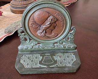 Art Nouveau / Art Deco cast iron bookend or expandable book rack end featuring a profile relief of the Roman goddess Minerva, made by the H.L. Judd Manufacturing Company of Wallingford, Connecticut, from the 1910s to 1920s.