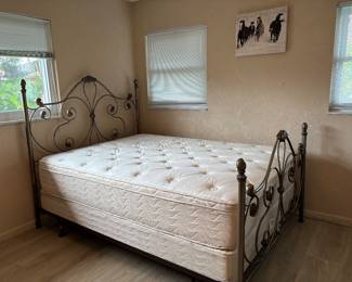 Full size bed with mattress and box springs.