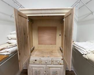 A49 - $100. Solid Wood Armoire with whitewash finish and floral design. Measures 43.75" x 22.25" x 76" tall. Doors slide into the cabinet.