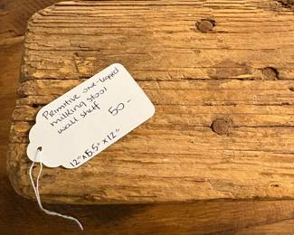 A60 - $50. Primitive One-Legged Milking Stool turned into a wall shelf. Measures 12" x 5.5" x 12" tall.