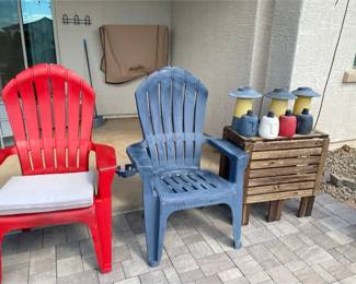Two Resin Chairs, A Table, And Some Oil Lamps
