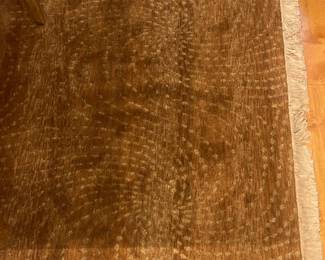 Wool brown hand knotted Rug 53 “ x 111 “ The pattern on this rug consists of concentric arcs or repeating rows of dotted textures that swirl slightly across the surface