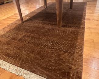 Wool brown hand knotted Rug 53 “ x 111 “ The pattern on this rug consists of concentric arcs or repeating rows of dotted textures that swirl slightly across the surface.
