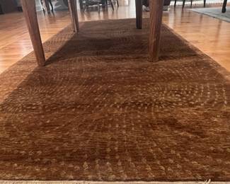 Wool brown hand knotted Rug 53 “ x 111 “ The pattern on this rug consists of concentric arcs or repeating rows of dotted textures that swirl slightly across the surface