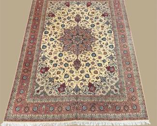 Traditional Persian-style area rug featuring an intricate central medallion, floral motifs in shades of rose, cream, and navy, and a fringed border.