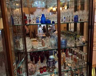Glass Curio Cabinet filled with crystal stemware and decoratives