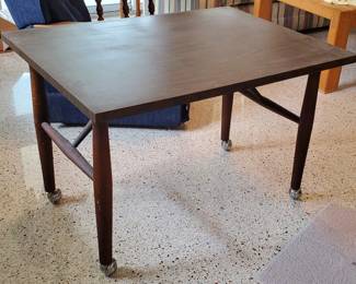 Mid-century table with tapered legs and original casters
