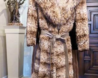 LOT 72 – Vintage 1974 Full-Length Lynx Fur Coat with Leather Belt. A full-length Lynx fur coat with an accompanying leather belt, c. 1974 in the owner’s notes. The broad collar and hem border are a rare Russian Lynx cat fur. Front, back and lining details are photographed. Approx. Size M or an ~8 to 8/10; Approx. Measurements: Waist: 30”, Bust: 36, Hips: 36.