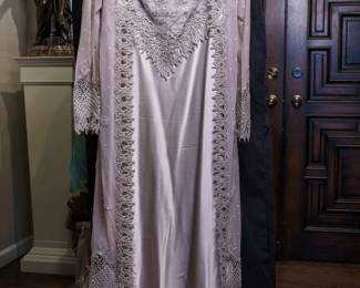 LOT 64 – Romantic Pale Gray-Lilac Silk Satin & Lace Evening Ensemble. A beautiful pale gray-lilac silk satin gown with a delicate lace bodice and slender spaghetti straps, creating the elegant, graceful look of a luxurious slip dress, that also comes with a lace insert. The gown is accompanied by a pale gray-lilac tulle and lace-net coat, featuring exquisite lace netting along the collar, cape opening, and lower front, beautifully finished with delicate appliqués and intricate lace borders. Designed by famous fashion and costume designer Margi Kent. Sold as a full ensemble set. • Approx. Size ~8 to 8/10; Approx. Measurements: Waist: 30”, Bust: 36, Hips: 36. • Owner’s note: the gowns can be adjusted in size; there is plenty of fabric in the seams.