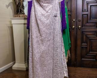 LOT 55 – Romantic Pale Lavender Gray Lace Evening Gown, with Satin Jacket. A breathtaking pale lavender gray lace-netting evening gown, lavishly embellished with hand-sewn sparkling sequins and 3-toned beadwork. The bust is beautifully ruched with layers of light rose and silver netting, richly encrusted with beads and sequins. Delicate pale lavender sheer lace forms the “poofy” capped sleeves, creating the enchanting look of a princess gown. The ensemble includes a pale lavender gray satin jacket with a ruched stand-up collar, embellished beaded buttons, and exquisite beadwork and sequins. Designed by famous fashion and costume designer Margi Kent. Sold as a full ensemble set. • Approx. Size ~8 to 8/10; Approx. Measurements: Waist: 30”, Bust: 36, Hips: 36. • Owner’s note: the gowns can be adjusted in size; there is plenty of fabric in the seams.
